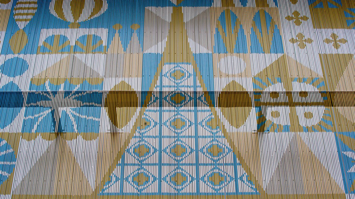 Motif central façade Kriskadecor – Habillage aluminium Disney Village - <p>Détail du motif central imprimé sur les chaînes aluminium Kriskadecor. La façade reproduit un graphisme géométrique sur maillons anodisés, démontrant la précision du système pour les projets architecturaux de grande échelle.</p>