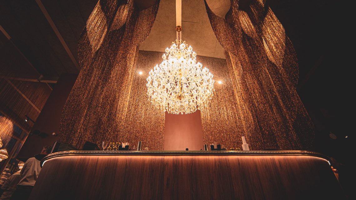 Lustre monumental en chaînes à maillons aluminium Kriskadecor - <p>Installation lumineuse suspendue en chaînes aluminium Kriskadecor créant un luminaire architectural de grande dimension.</p>