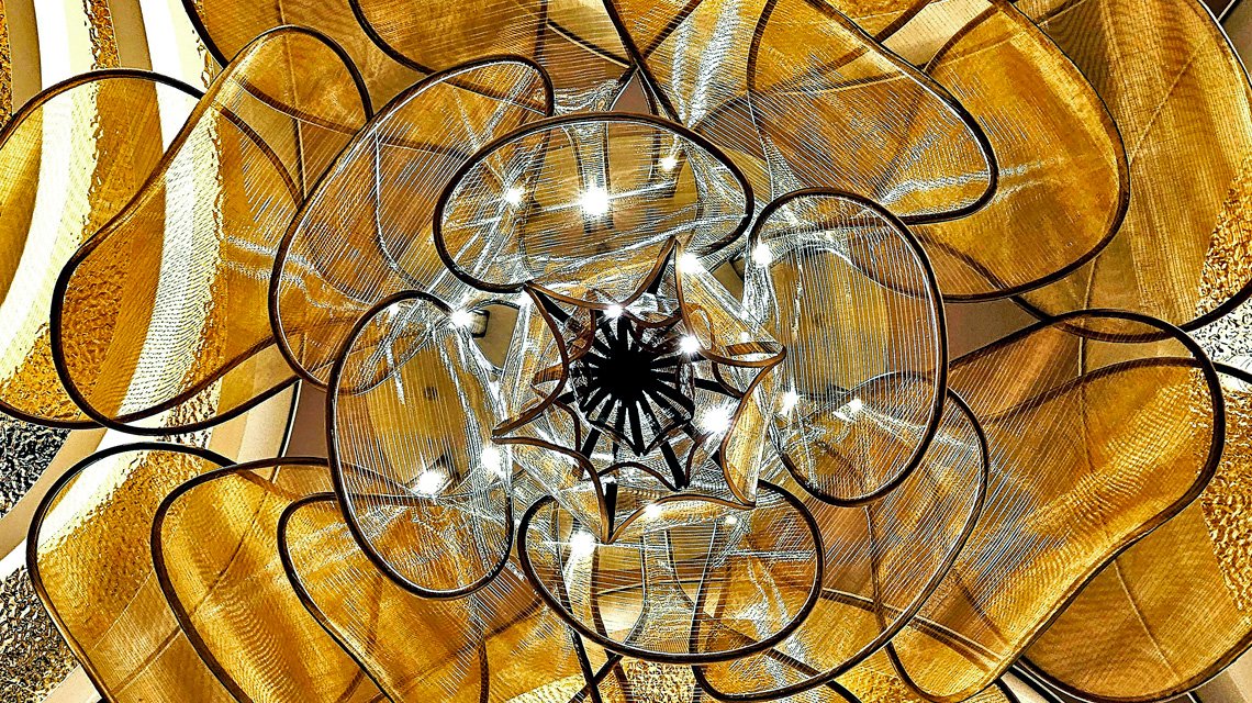 Restaurant Le Voyage – Chandelier en maille métallique - <p>Vue du chandelier monumental en maille métallique intégré à l’architecture intérieure du restaurant Le Voyage à bord du Celebrity Xcel.</p>