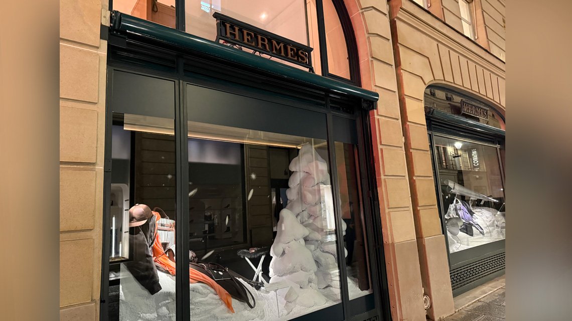 Vitrine Hermès Paris – installation de Noël avec touches de maille Aura Inox - <p>Vue extérieure de la vitrine Hermès à Paris présentant la scénographie hivernale. Les touches de maille métallique Aura Inox apportent un éclat subtil et une texture contemporaine aux objets exposés.</p>