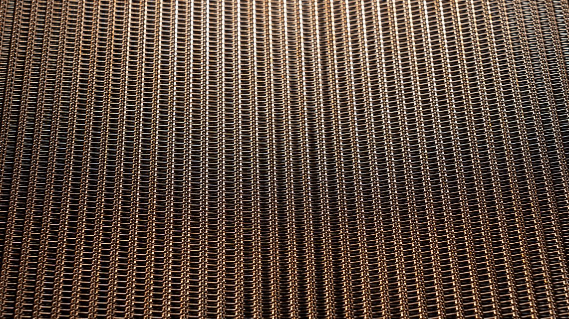 MINI RIVER BRONZE – Résille métallique souple et ajourée pour architecture intérieure - <p>Vue en perspective de la résille métallique MINI RIVER BRONZE illustrant sa structure ouverte et son rendu décoratif. Avec une surface ouverte de 49&nbsp;%, cette maille architecturale en bronze permet de jouer avec la transparence et les effets de lumière dans les séparations d’espaces, rideaux métalliques et habillages intérieurs.</p>