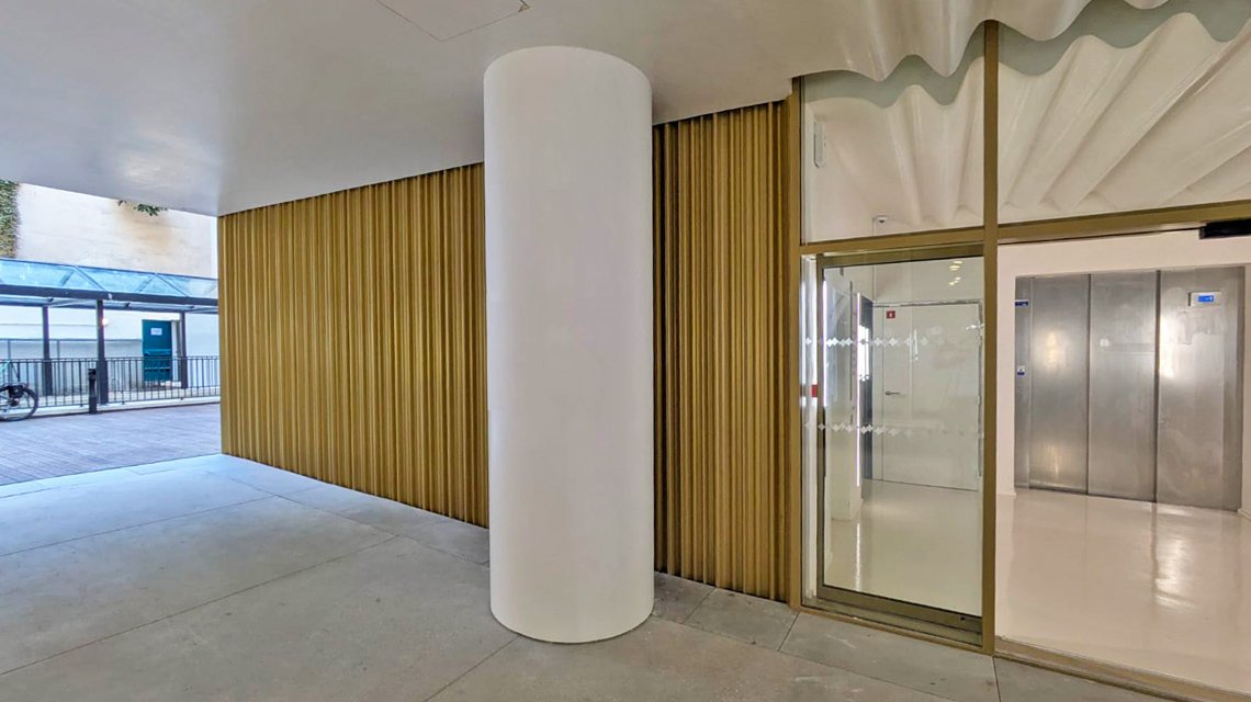 Tôle ondulée champagne en habillage mural  - <p>Tôle ondulée champagne en habillage mural pour ce hall de bâtiment parisien. Réalisation sur mesure avec 3 modèles d’ondulation de notre fabricant.</p>