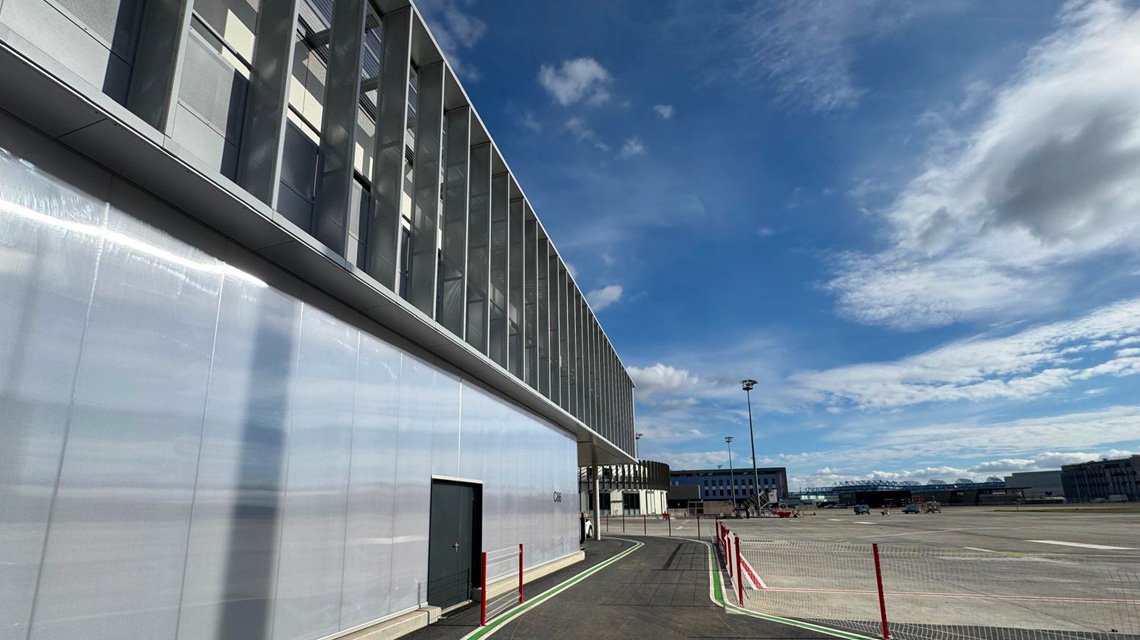 Façade industrielle et brise-soleil métallique - <p>Vue générale du Delivery Center Airbus Ziegler intégrant une pergola équipée d’une grille électro-soudée Slot en protection solaire.</p>
