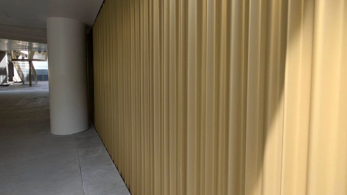 Tôle ondulée champagne en habillage mural pour ce hall de bâtiment parisien. - <p>Tôle ondulée champagne en habillage mural pour ce hall de bâtiment parisien. Réalisation sur mesure avec 3 modèles d’ondulation de notre fabricant.</p>